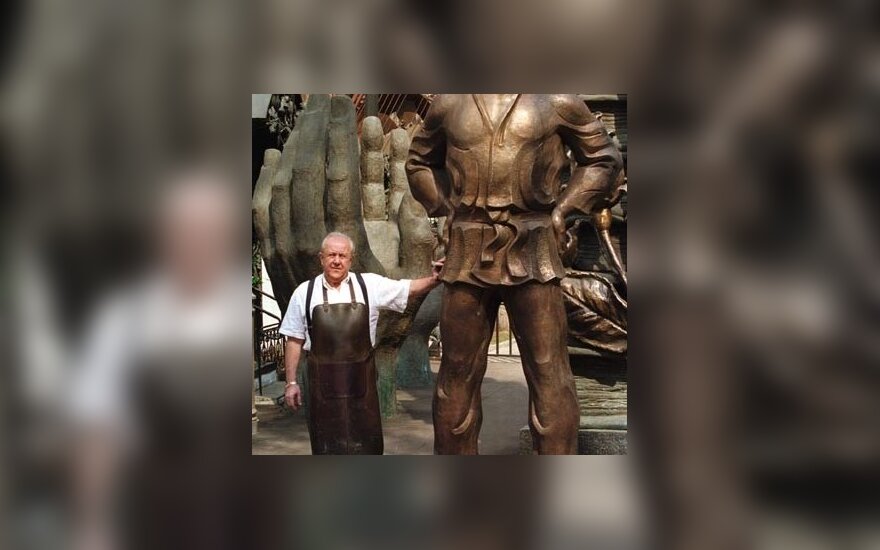 Rusų skulptorius Zurabas Cereteli pozuoja greta bronzinės Rusijos prezidento Vladimiro Putino statulos. 