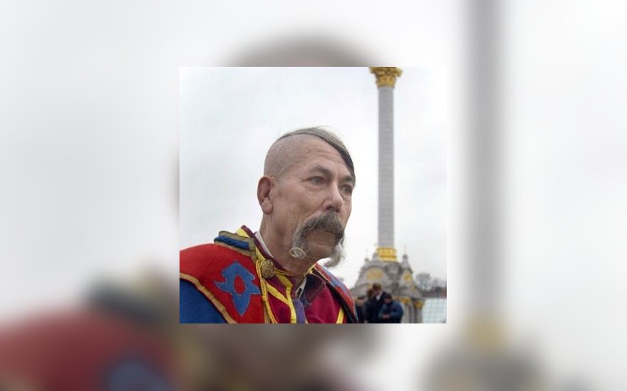 Vyras, apsirengęs tradiciniais Ukrainos kazoko drabužiais, eina pro Nepriklausomybės paminklą Kijeve. 