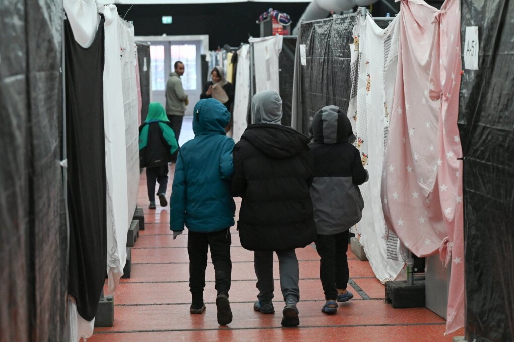 PRODUCTION - 10 February 2023, Hesse, Bensheim: Refugee children walk through a tent of the refugee shelter. Cities and communities can hardly accommodate the number of refugees. The Bergstrasse district is not alone in calling for more support from the federal and state governments. Photo: Arne Dedert/dpa