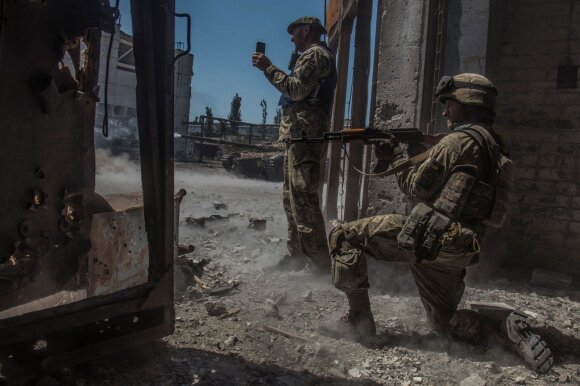 Ukrainos kariai stebi, kaip iš tanko apšaudomos Rusijos pajėgos pramoniniame Sjeverodonecko rajone. 2022 birželio 20 d. 