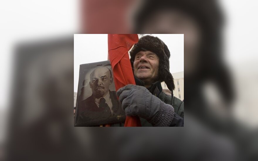 Vyras laiko Lenino portretą ir Sovietų vėliavą Minsko Nepriklausomybės aikštėje vykstančiame minėjime