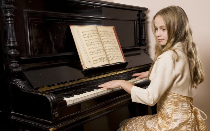 Mergaitė groja pianinu