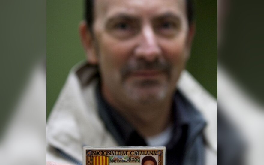 Nuo Ispanijos atsiskirti norintis  katalonietis rodo simbolinę regiono tapatybės kortelę. 