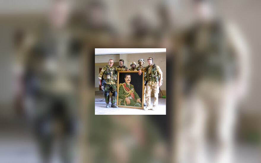 Britų kariai pozuoja prie S.Husseino portreto