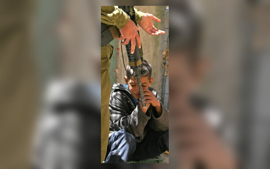 Izraelio karys stovi prie sulaikyto devynmečio palestiniečio berniuko