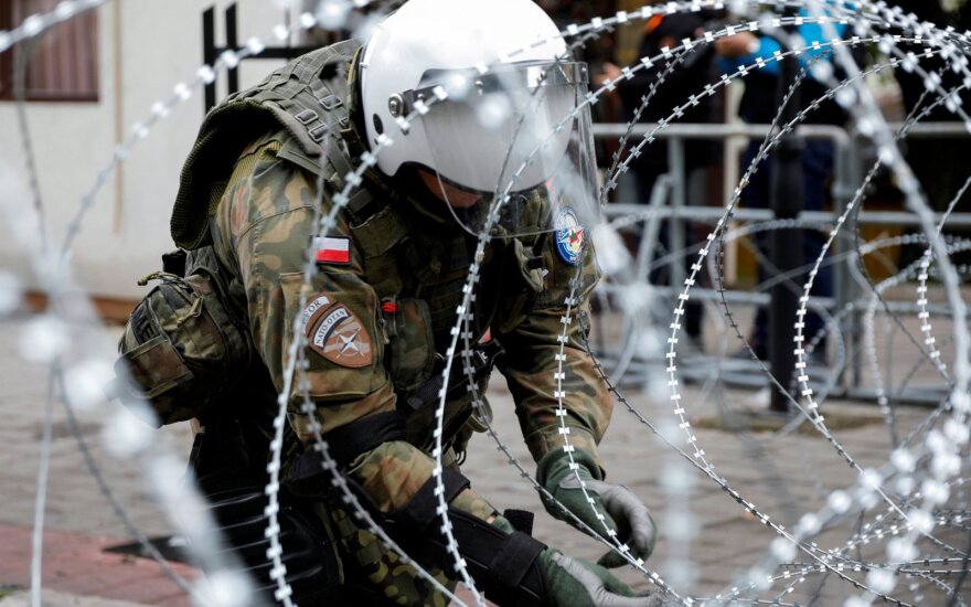 A Polish member of the NATO-led Kosovo Force (KFOR) sets up a wire fencing as they stand guard near a municipal office in Zvecan, Kosovo, May 31, 2023. REUTERS/Ognen Teofilovski