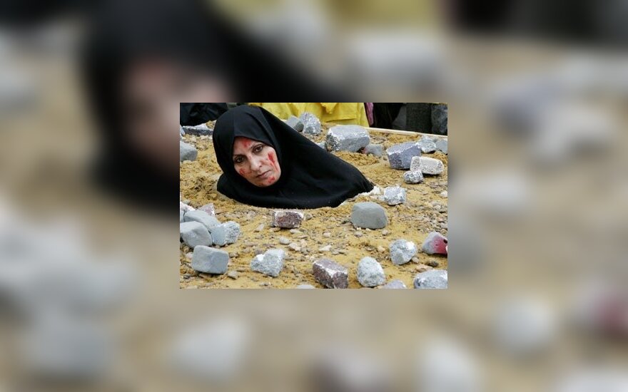 Iranietė moteris, vaizduodama akmenimis užmuštą auką, protestuoja BriuselyjeIranietė moteris, vaizduodama akmenimis užmuštą auką, protestuoja Briuselyje. Asociatyvinė nuotr.