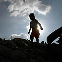 vaikas vaikštinėja po griuvėsius