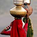 Indės ant galvų neša didžiulius indus su vandeniu. Indijos kaimuose moterims tenka nueiti daugelį kilometrų, kad parneštų geriamo vandens.