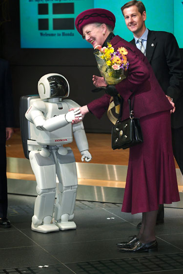 Danijos karalienė Margareta II viešnagės Japonijoje metu sveikinasi su robotu.