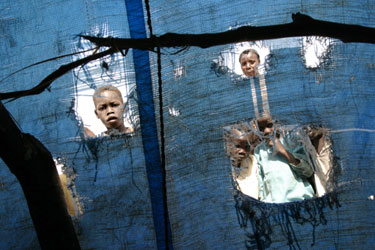 Perkraustomi Sudano vaikai žiūri pro palapinės skyles