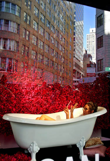 modelis Megan Gale guli vonioje, kuri pastatyta Sidnėjaus universalinės parduotuvės vitrinoje