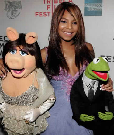 Dainininkė Ashanti Tribecos filmų festivalyje, vykstančiame Niujorke, pozuoja su lėlėmis - panele Piggy ir Kermitu