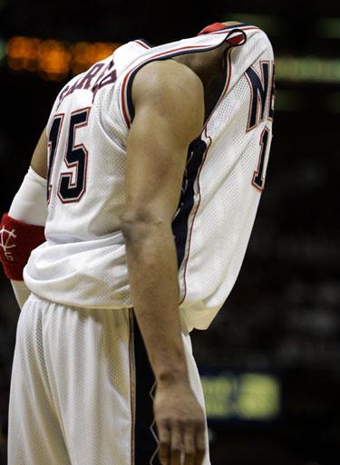 Nju Džersio “Nets” atakuojantysis gynėjas Vince Carteris slepia galvą marškinėliuose rungtynėse su “Miami Heat”.