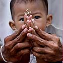 Balio salos gyventojas (Indonezija) su sūnumi meldžiasi šventykloje.