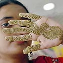 Jaunoji Bangladešo gyventoja rodo chna dažais išmargintą ranką.