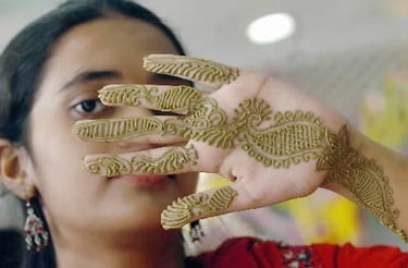 Jaunoji Bangladešo gyventoja rodo chna dažais išmargintą ranką.