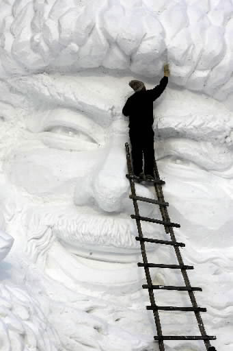 Kinų menininkas skaptuoja skulptūrą iš sniego